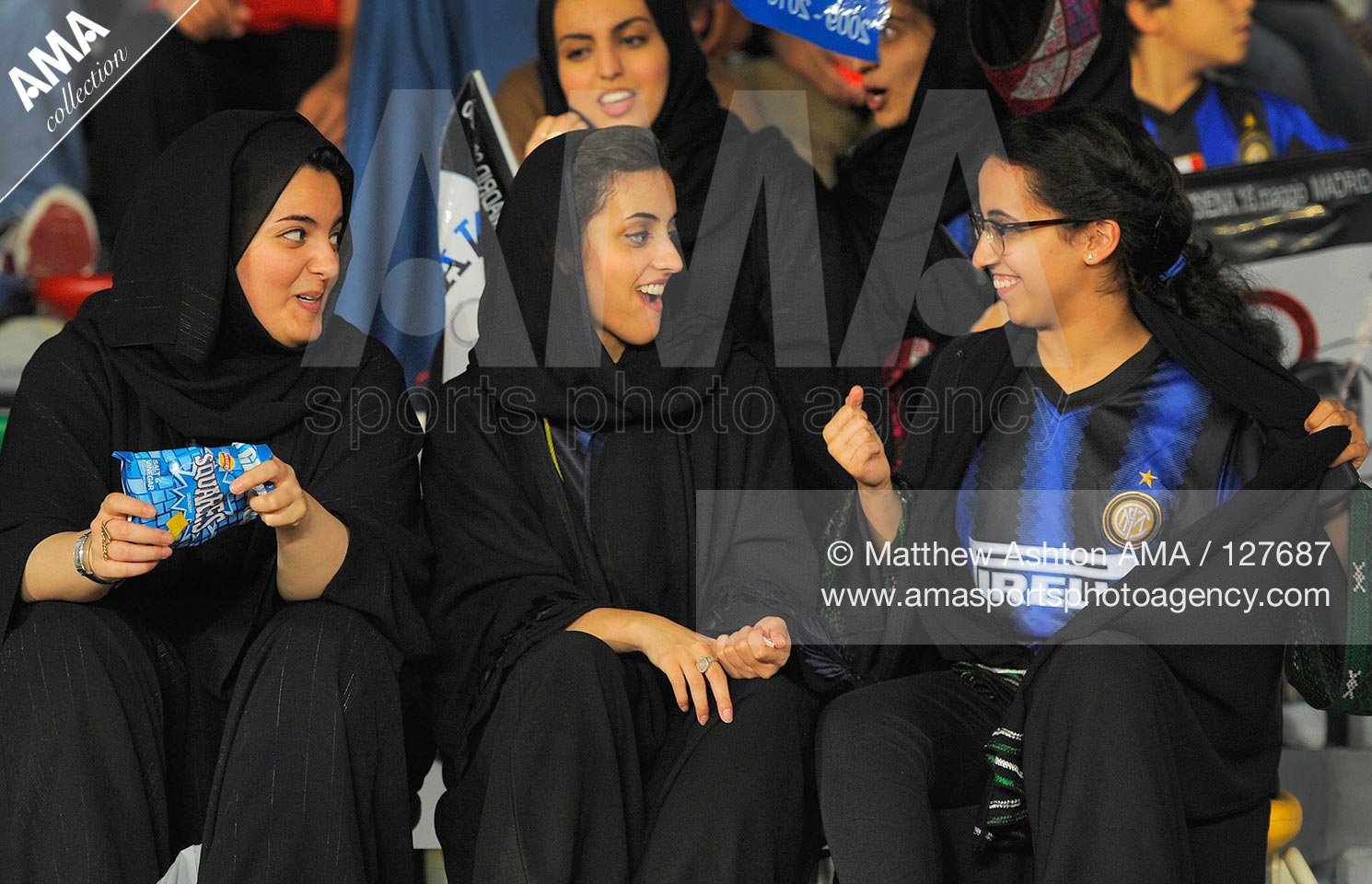 15 December 2010 - FIFA Club World Cup - Semi Final - Seongnam Ilhwa Chunma FC v FC Internazionale - Local United Arab Emirates girl football fans act shocked as one of their friends shows off an Inter Milan shirt underneath her Abaya black Islamic dress 