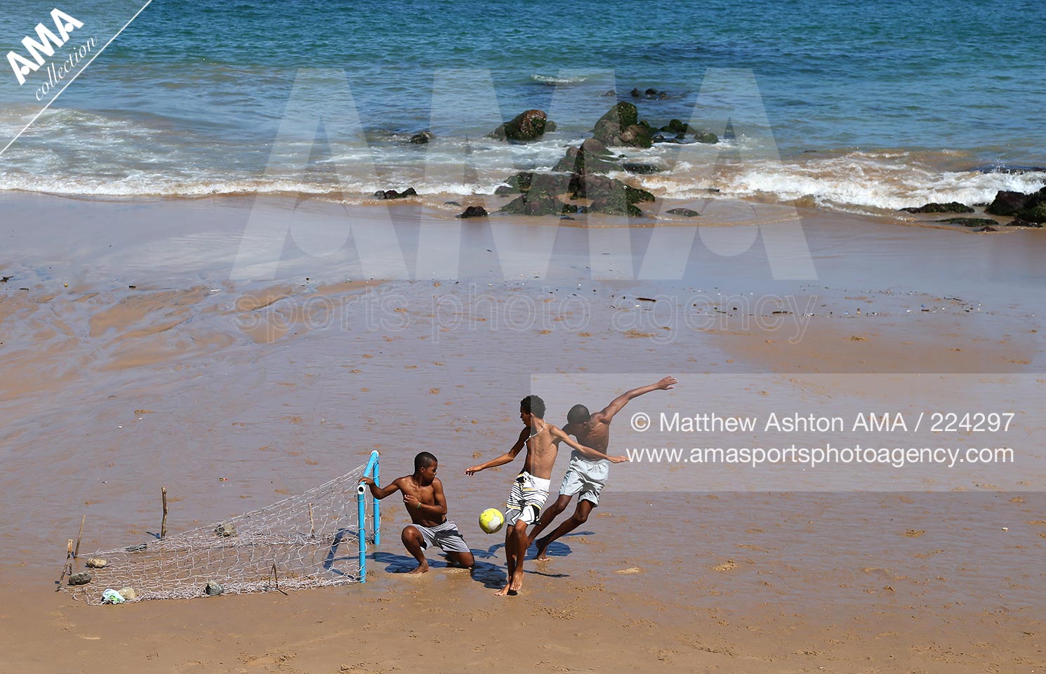 23 June 2013 - Brazil Football Culture - A goal net on the sand as locals play beach football on a Sunday morning along the Praia do Farol da Barra, Salvaldor, Bahia, Brazil on the Atlantic Ocean coastline