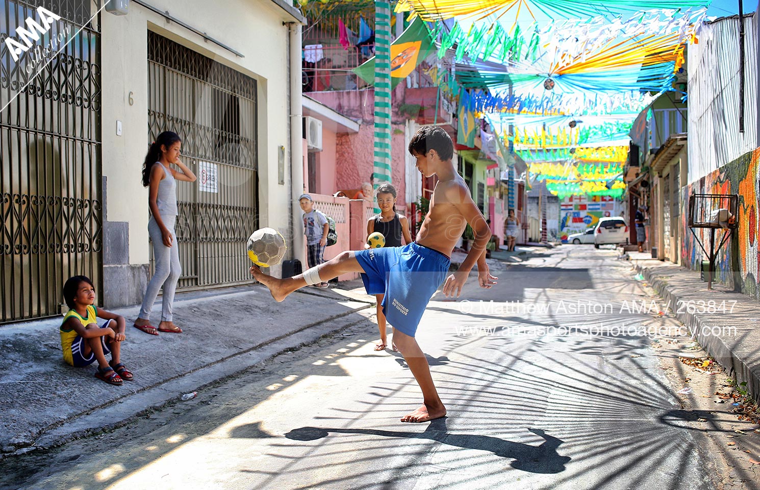 14 June 2014 - FIFA World Cup Brazil 2014 - A young boy kicks a football in the decorated streets around Rua Lores Cordovil in Manaus, Brazil