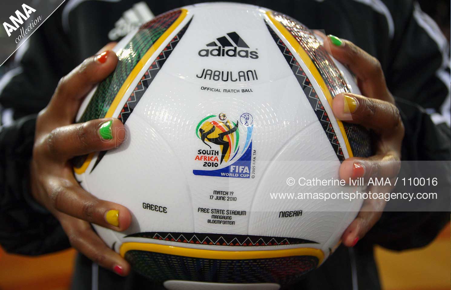 A Ballgirl with painted nails holds the official Jabulani ball for the Greece v Nigeria match