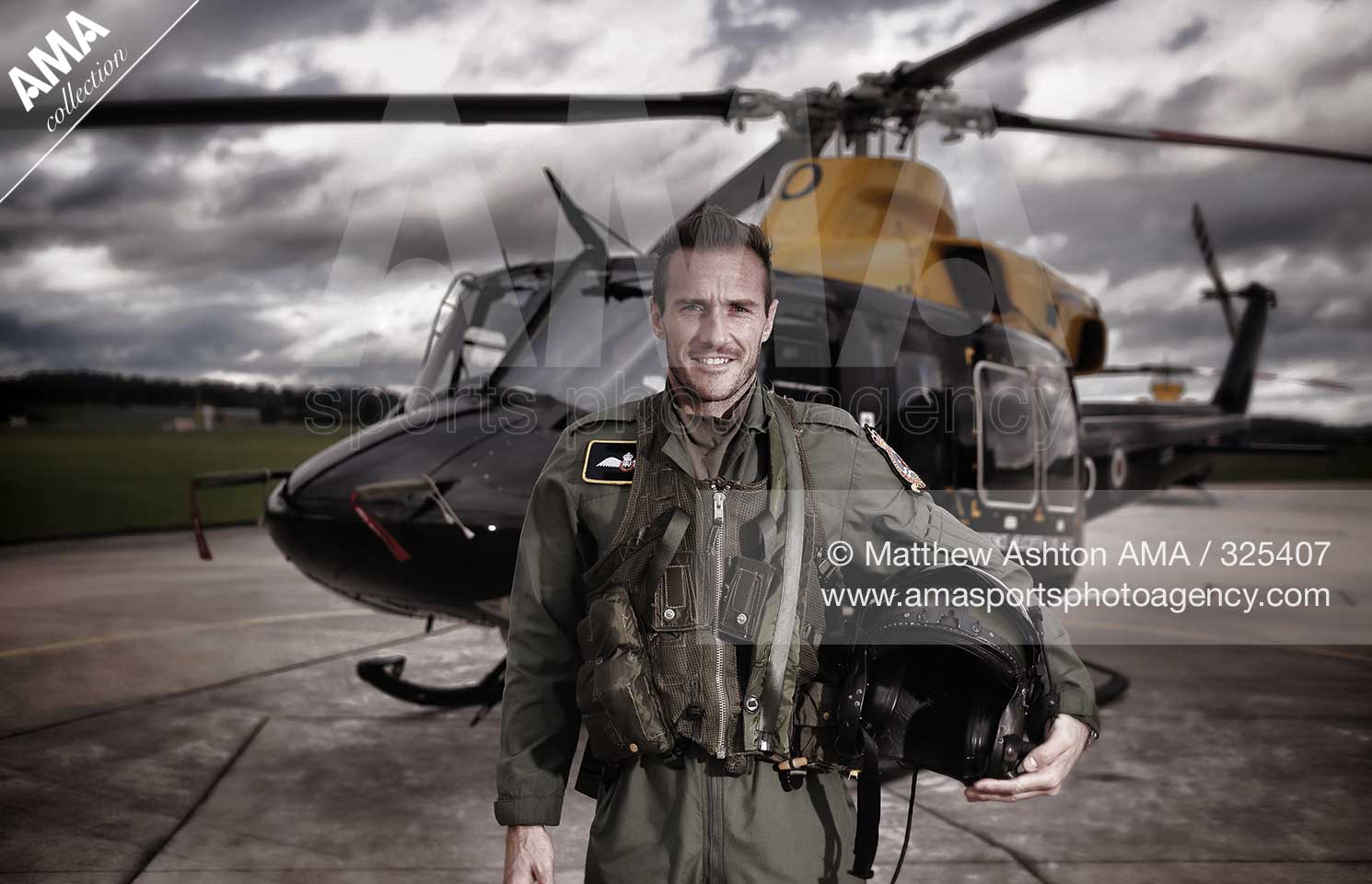 Liam Lawrence of Shrewsbury Town dressed as a helicopter pilot in front of a Griffin Helicopter at RAF Shawbury