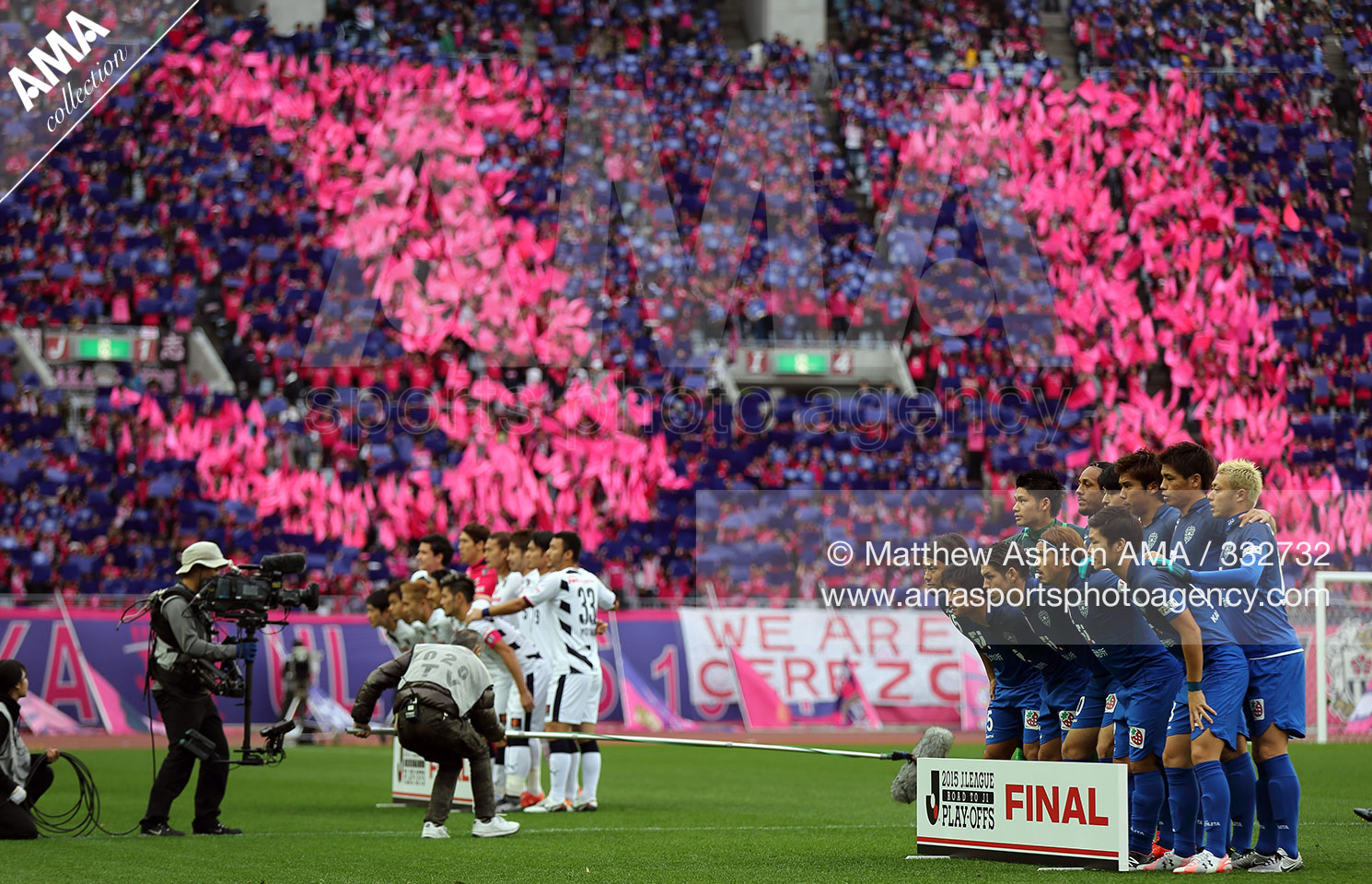  2015 J League Road to J2 Play Off Final - Avispa Fukuoka v Cerezo Osaka - Cerezo Osaka and Avispa Fukoka pose for team groups as Cerezo Osaka fans display J1 in the hope of promotion from J2 