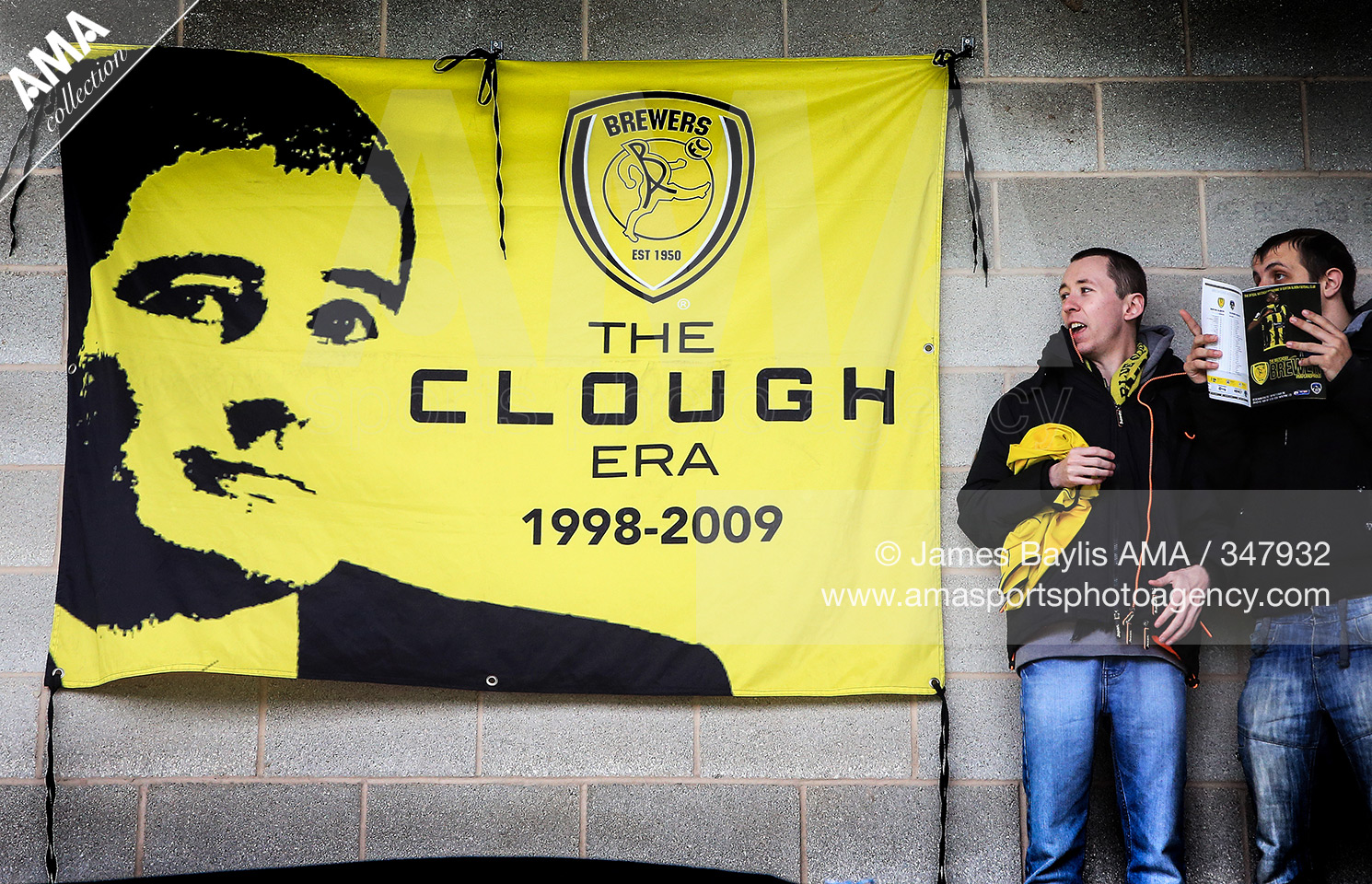 26 March 2016 Sky Bet League One - Burton Albion v Oldham Athletic- Burton Albion supporters stand next to a flag that says 'The Clough era 1998-2009' © James Baylis / AMA 347932