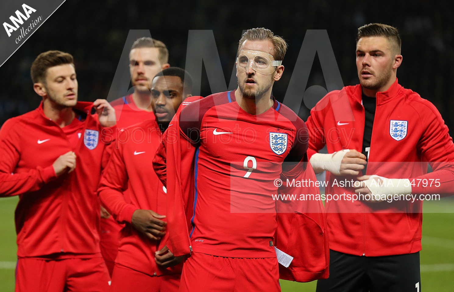 26 March 2016 International Friendly - Germany v England Harry Kane of England and his team-mates remove their tracksuits to show off the new red Nike away kit © Matthew Ashton / AMA 347975